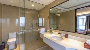 A modern bathroom with a glass-enclosed shower, a white sink, and a large mirror.