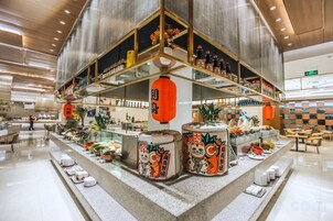 A modern interior with a central display of various items, including decorative containers and a seating area.
