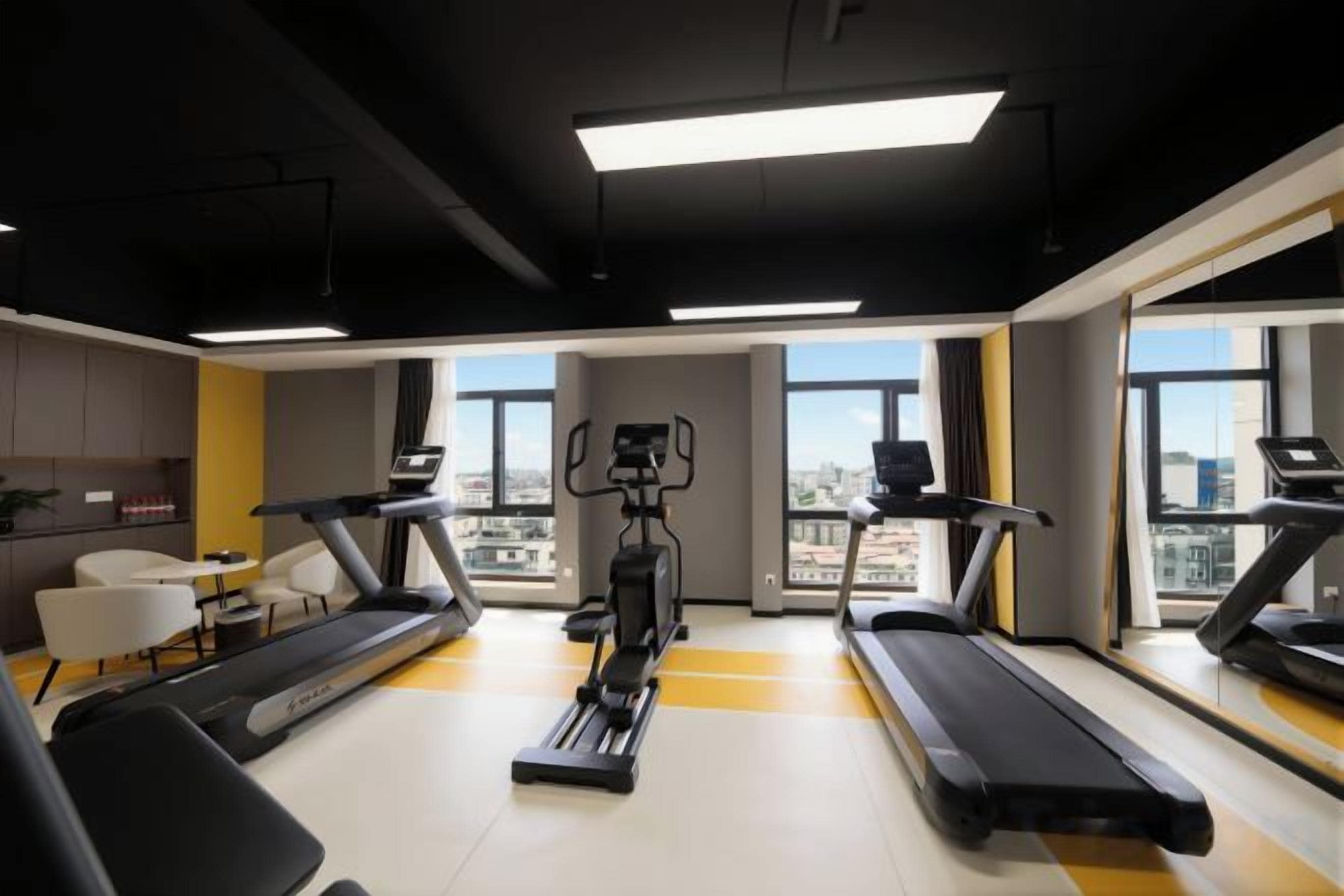 Une salle de sport équipée de tapis de course, d’un vélo d’appartement et d’un appareil d’aviron.