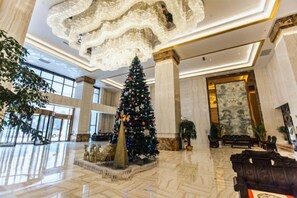 A spacious lobby with a large Christmas tree, marble flooring, and a grand chandelier. - Ruixue International Hotel (Gao'an)