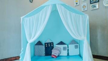A room with a canopy bed, a small bedside table, and wall decorations.