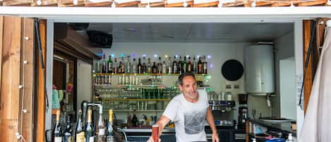 A bar named "LE DRAKKAR" with a wooden interior and a variety of bottles and glasses on shelves.