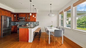 A modern kitchen with wooden cabinets, stainless steel appliances, and a central island.