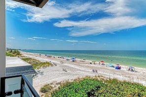 A beach with umbrellas, lounge chairs, and a view of the ocean. - BUENA VISTA 4 - LUXURY BEACHFRONT - Anna Maria Island - By Island Real Estate Va (Holmes Beach)