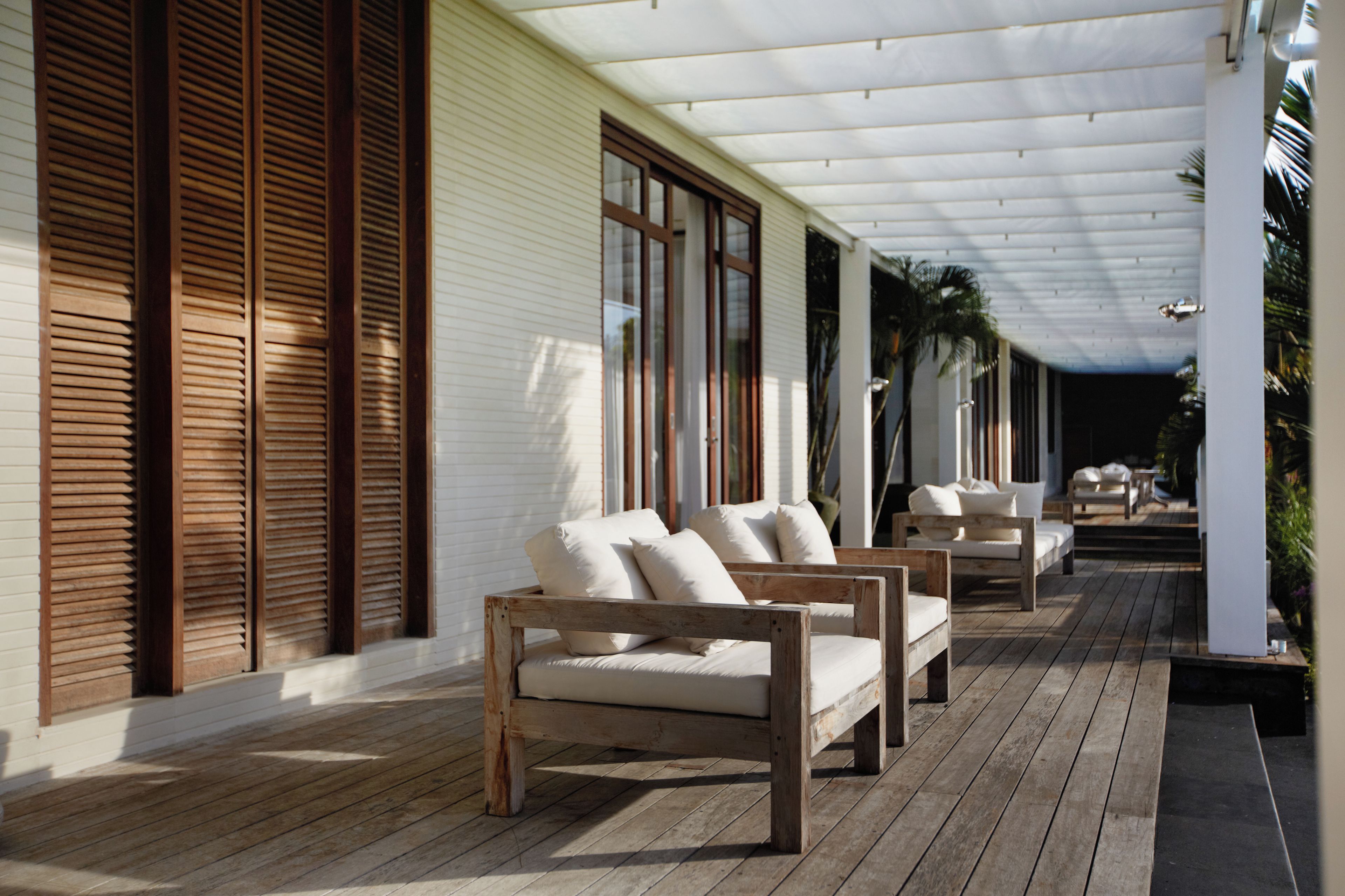 Un espace extérieur aménagé, abrité et doté de mobilier en bois et d’une terrasse en bois.