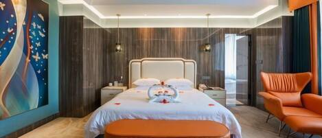 A modern hotel room with a large bed, a bench, a chair, and a large abstract painting on the wall.