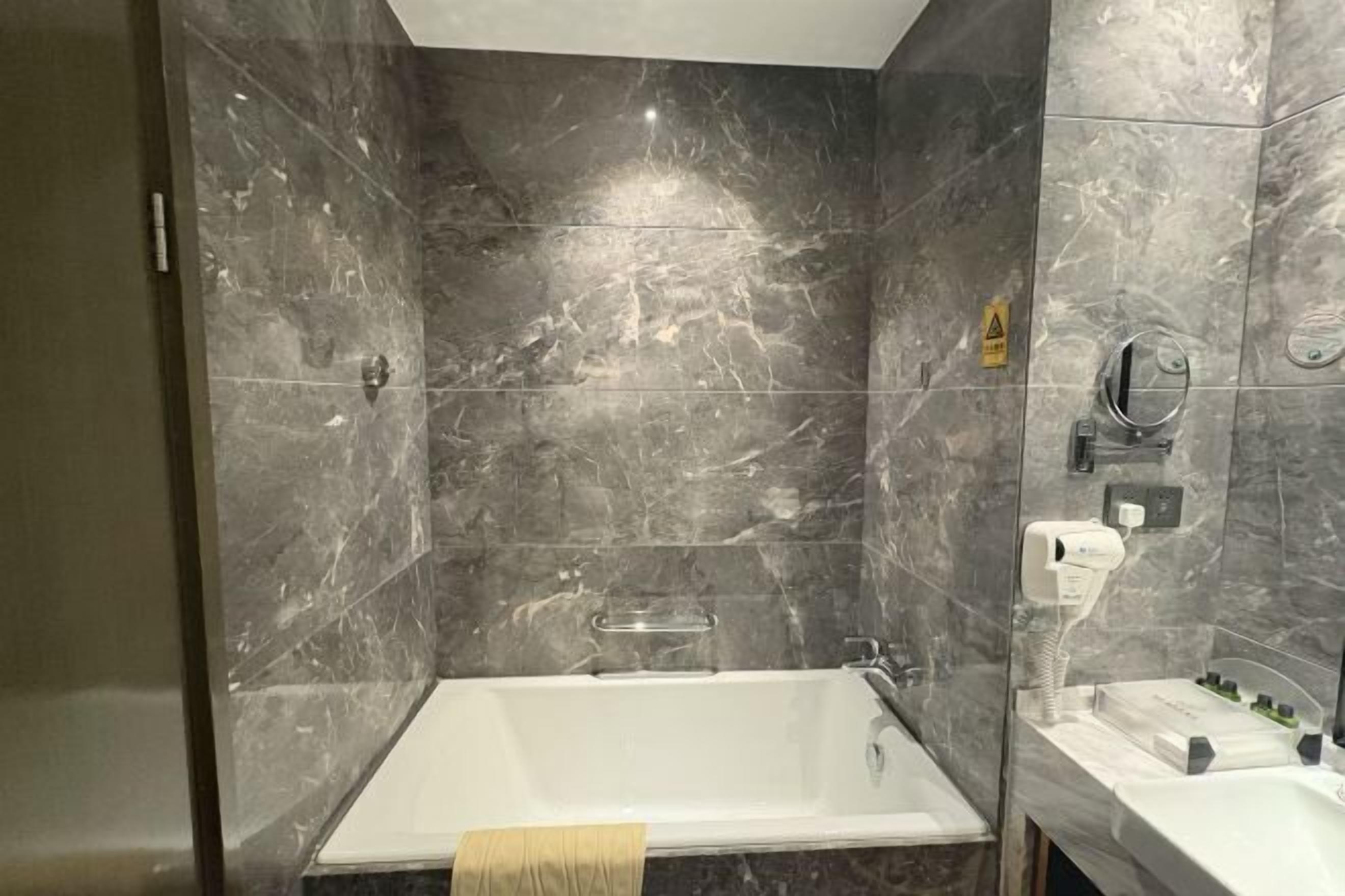 Un baño con bañera, lavamanos y zona de ducha.