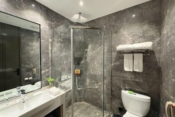 A modern bathroom with a glass-enclosed shower, a white sink, and a toilet.