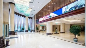 A spacious lobby with marble flooring, large columns, and a modern chandelier. - Yangzi International Hotel (Liyang)