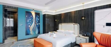 A modern hotel room with a large bed, a seating area, and a painting on the wall.