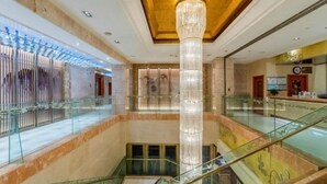 A spacious lobby with a grand chandelier, marble floors, and a glass railing on the upper level. - Yangzi International Hotel (Liyang)