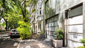 Ein modernes Gebäude mit einer Garagentür, auf der “Amsterdam 268” steht.