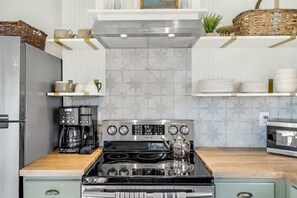 A kitchen with a stainless steel stove, a coffee maker, and a microwave.