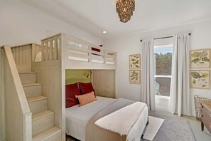Ein Schlafzimmer mit Etagenbett, einer Treppe, einem Chandelier und Blick ins Freie.