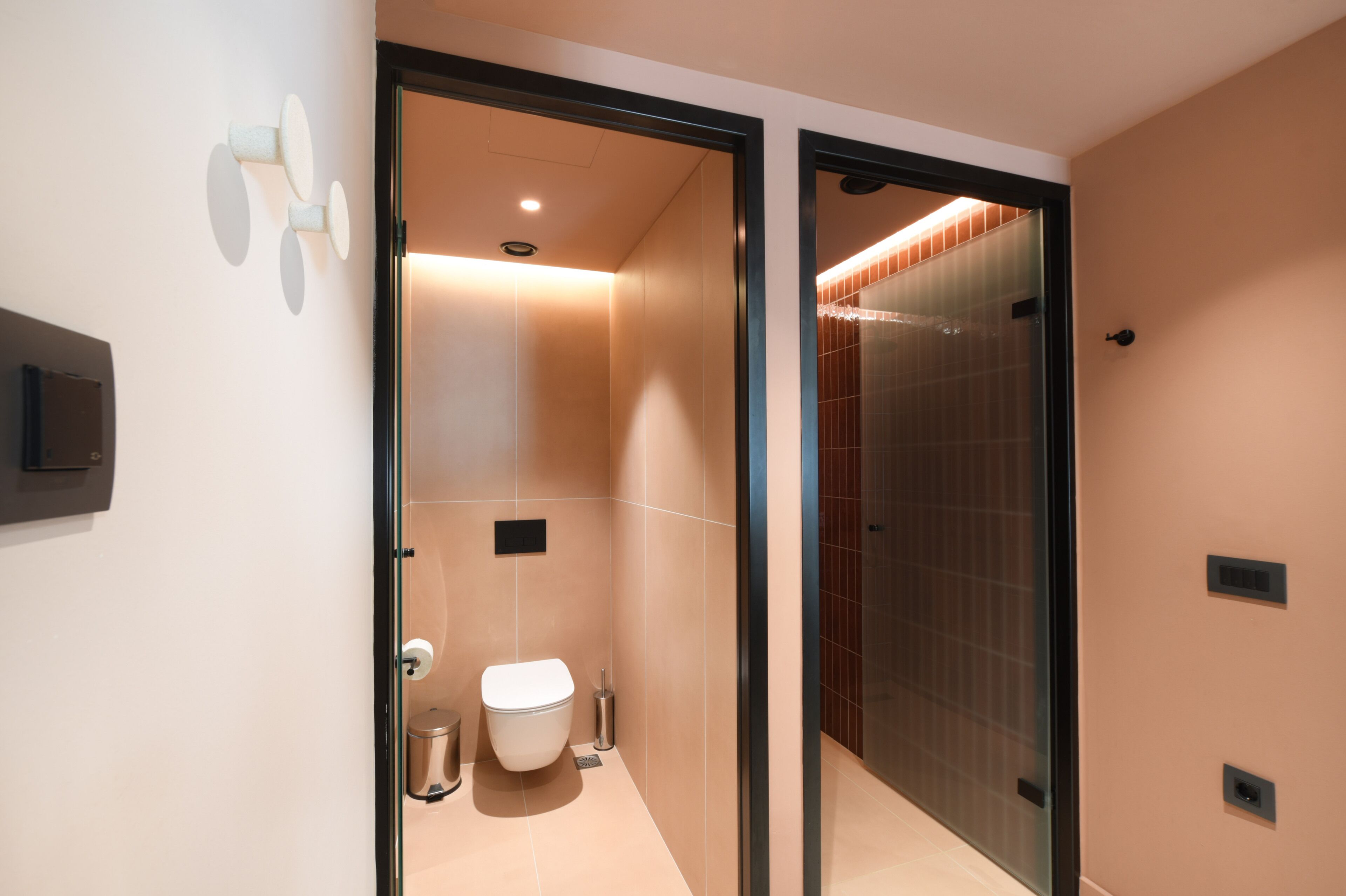 Un baño moderno con inodoro, bidé y cabina de ducha de vidrio.