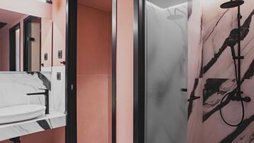 Une salle de bain moderne avec un lavabo en marbre, une cabine de douche en verre et un motif mural en marbre.