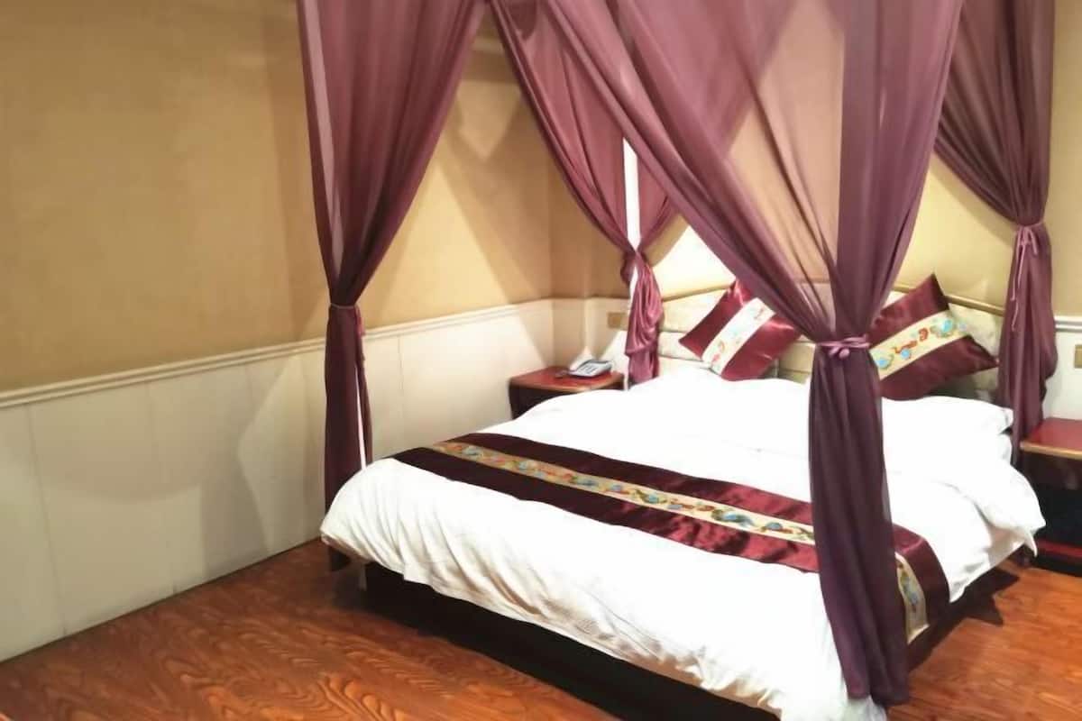 Une chambre à coucher avec un lit à baldaquin, une table de chevet avec une lampe et un téléphone.