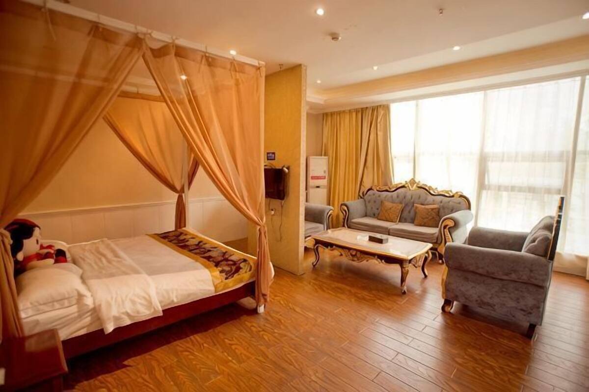 Une chambre à coucher avec un lit à baldaquin, un canapé et une table basse.
