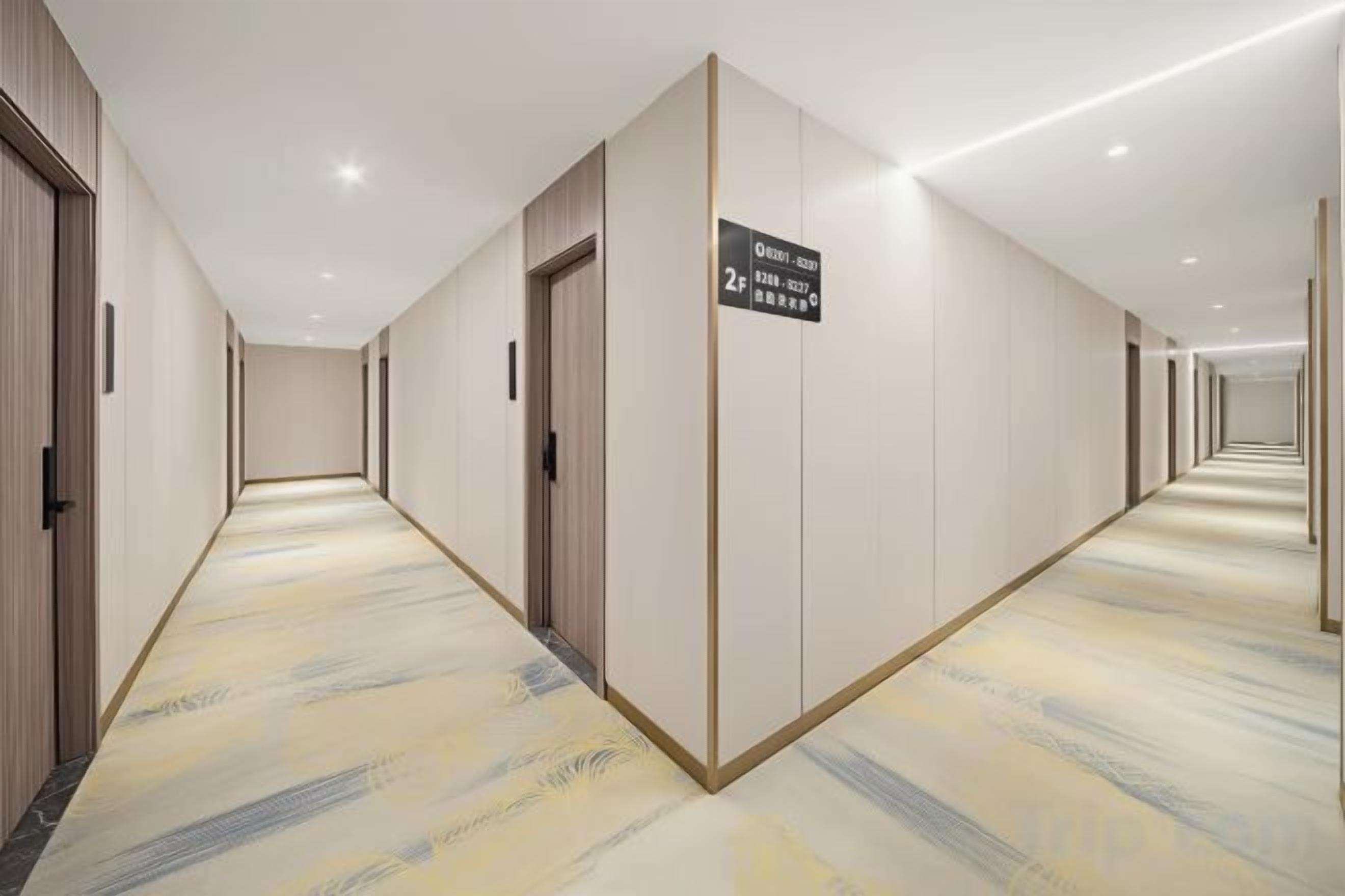 A hotel corridor with doors, a carpeted floor, and a sign indicating the direction to the 2nd floor.