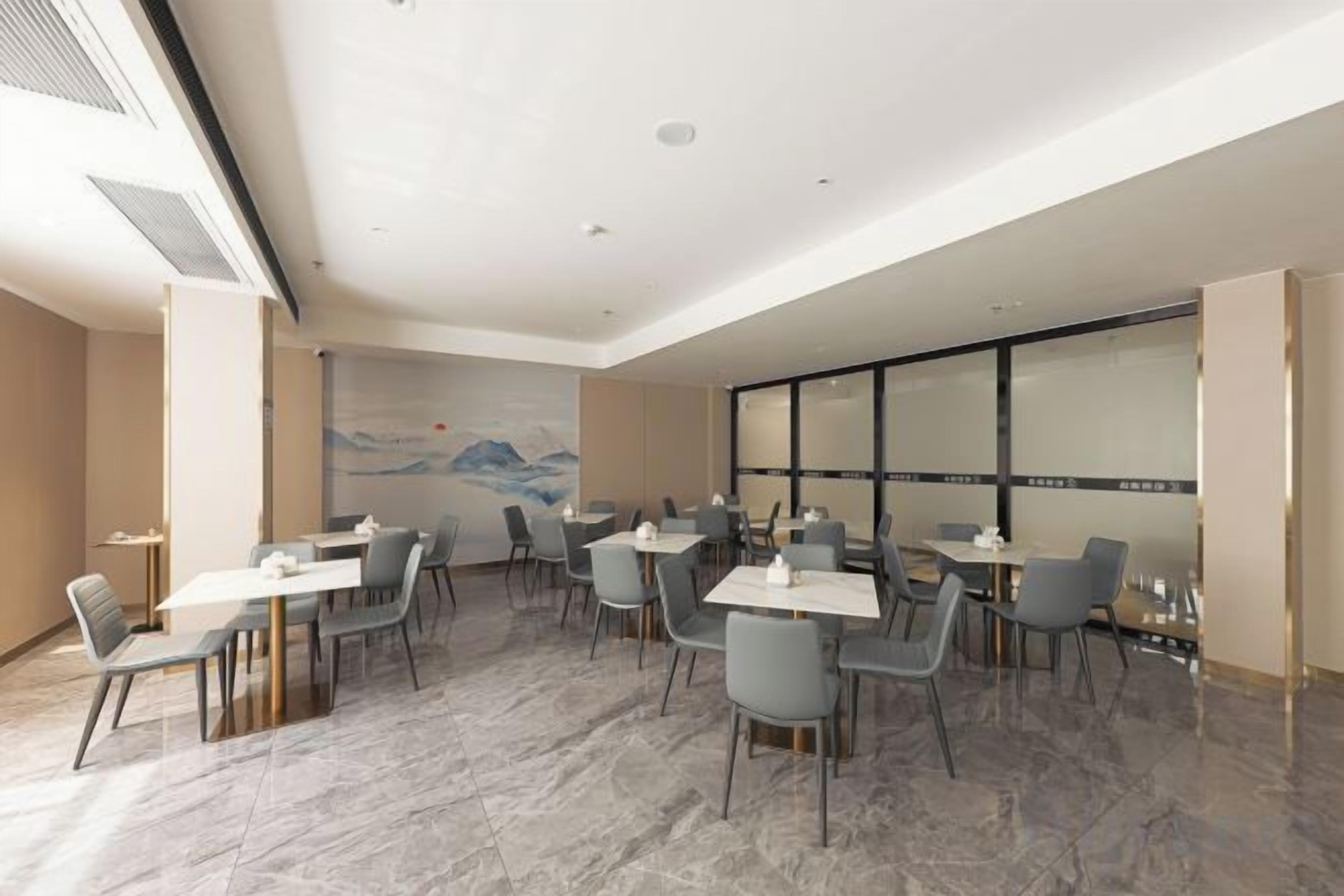 A spacious dining area with marble flooring, modern chairs, and tables arranged for dining.
