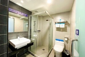 Une salle de bain moderne avec une douche à parois de verre, un lavabo blanc et des toilettes.