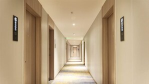 A hotel hallway with wooden doors and a carpeted floor. - Jiangmen ParkLane Hotel (Xiangshan Park Xinqiao Branch) (Jiangmen)