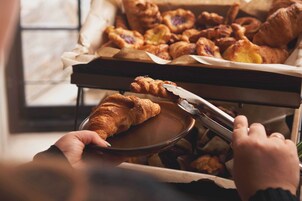 Bandeja con una selección de pastelería, incluyendo croissants y tartas, que se sirve.