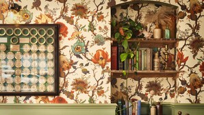 Une pièce avec un papier peint à motifs floraux, une collection de bouteilles anciennes encadrées et une bibliothèque remplie de livres et d’objets décoratifs.