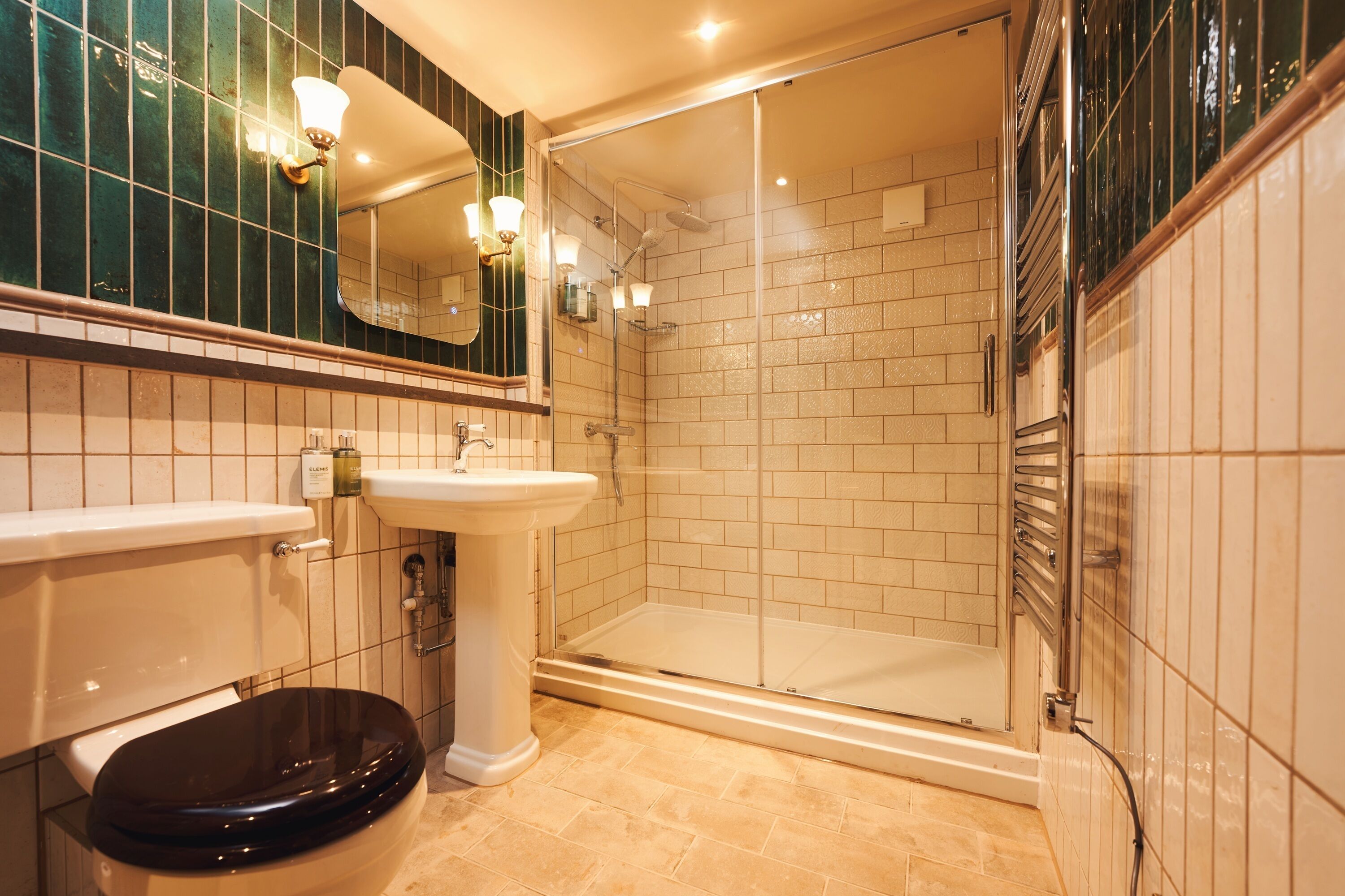 A bathroom with a toilet, sink, and shower area.