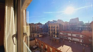 A view of a cityscape with multiple buildings, a clear sky, and a sun shining. - Plaza Universitat Apartment (Barcelona)
