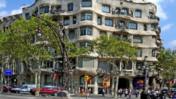 A building with a unique architectural style, featuring multiple balconies and a curved facade. - Plaza Universitat Apartment (Barcelona)