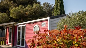 A pink and white building with a number '360' on the side, surrounded by trees and plants. - Camping de l'Arquet Cote Bleue (Martigues)