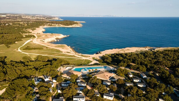 An aerial view of a coastal residential area with houses, a swimming pool, and a beach. - Camping de l'Arquet Cote Bleue (Martigues)