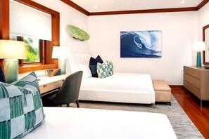 Ein Hotelzimmer mit Bett, Schreibtisch, Sessel, Sofa und einem Wellenbild an der Wand.
