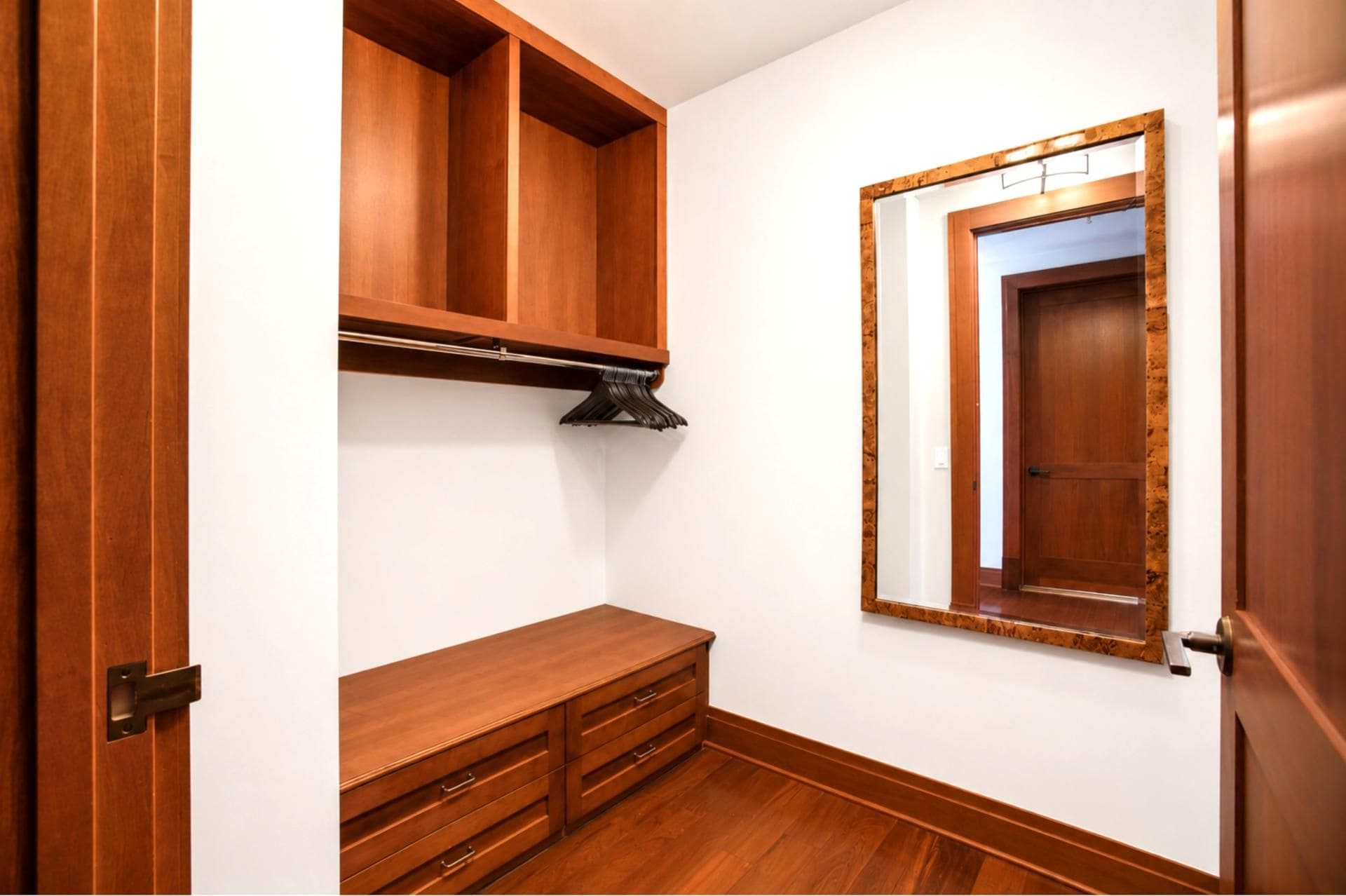 Ein Zimmer mit Holzkorpusen, einer Sitzbank und einem Fenster mit Holzrahmen.