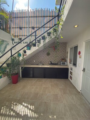 L’intérieur d’un hôtel, avec un escalier, un coin cuisine et un sol carrelé.