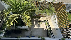 A rooftop garden with potted plants and a seating area.