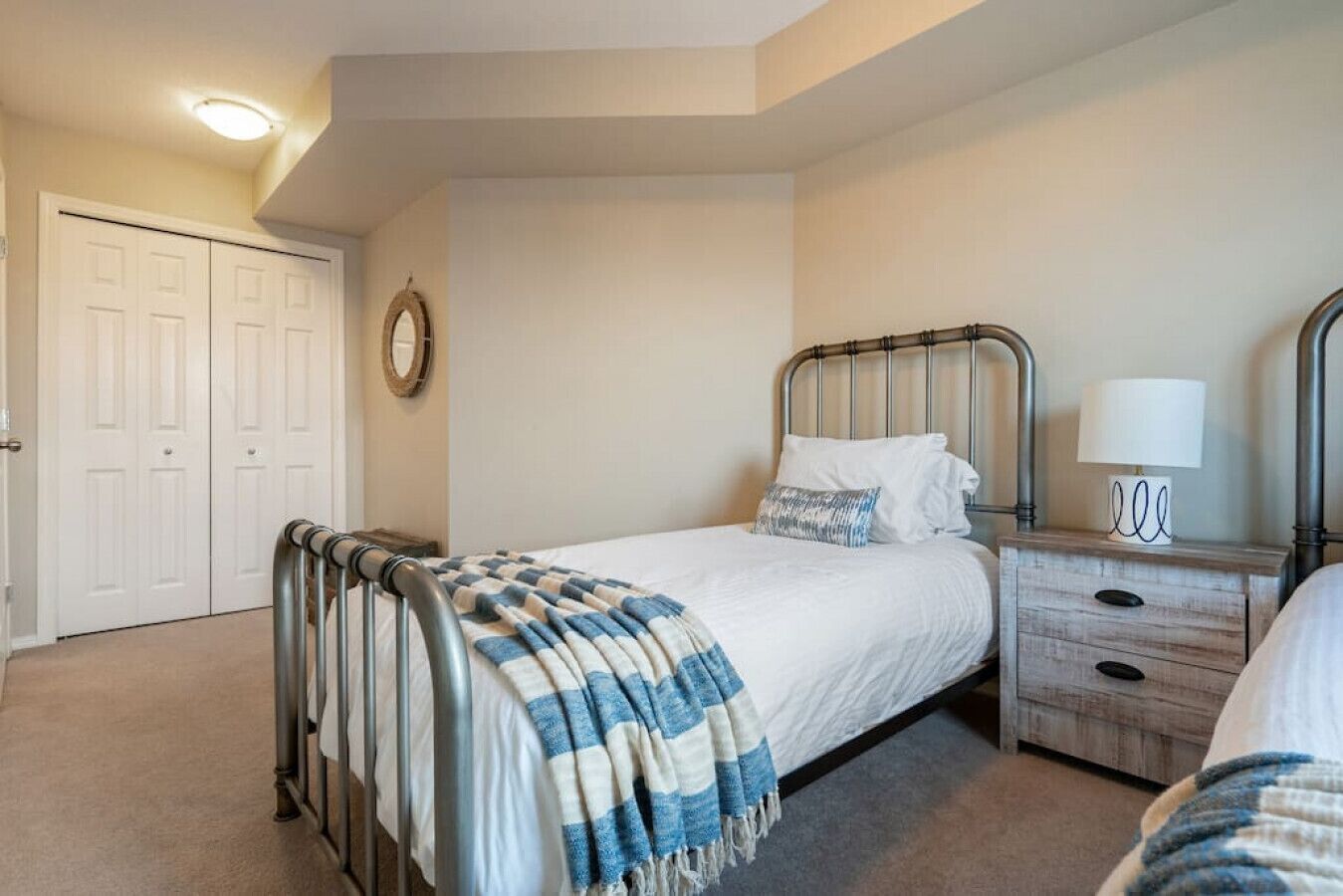 A bedroom with a bed, bedside table, lamp, and a wardrobe.