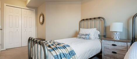 A bedroom with a bed, bedside table, lamp, and a wardrobe.