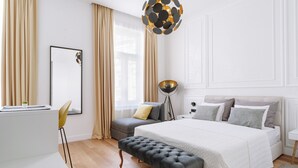 A modern bedroom with a large bed, a desk, and a chair.