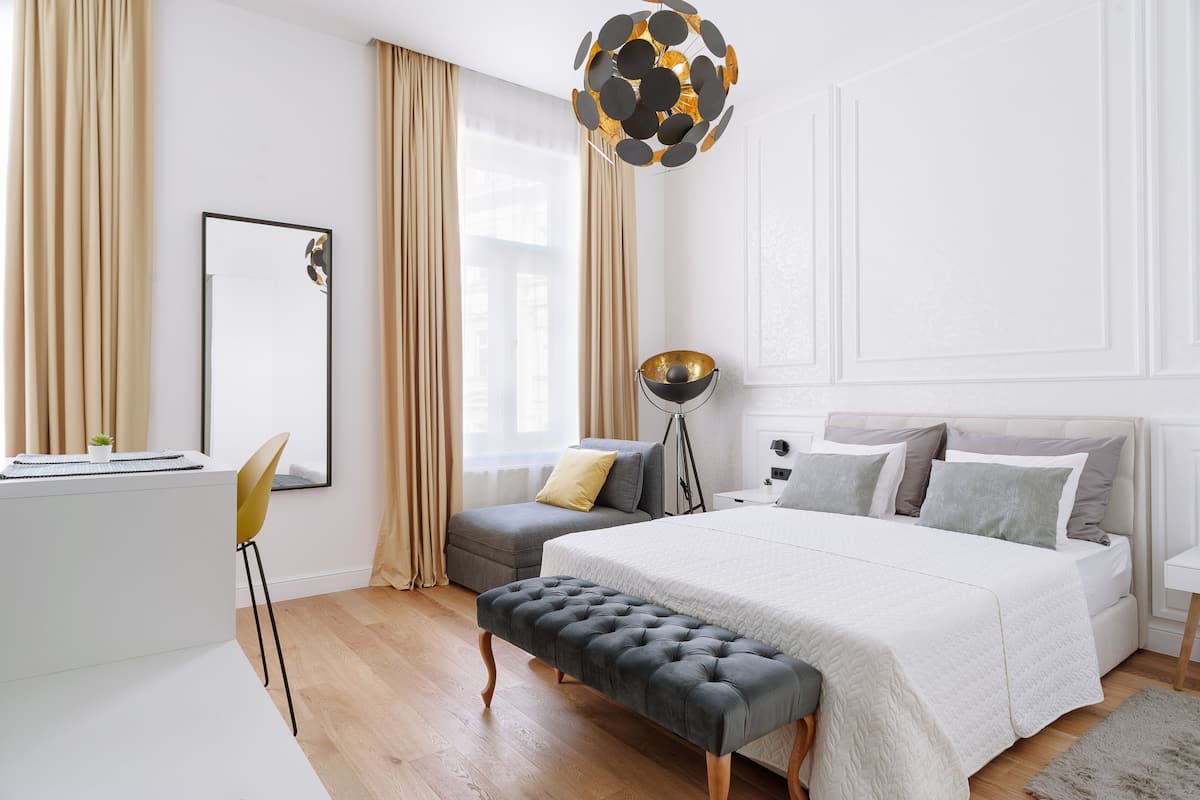 A modern bedroom with a large bed, a desk, and a chair.