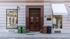 A building with a brown wooden door, a large window with mannequins, and a sign indicating a 50% discount.
