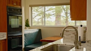 A kitchen with a built-in oven, a sink with a modern faucet, a wooden countertop, and a window with a view of trees. - Upscale, Nature Views, Family Retreat for a great Mountain Getaway (Flagstaff)