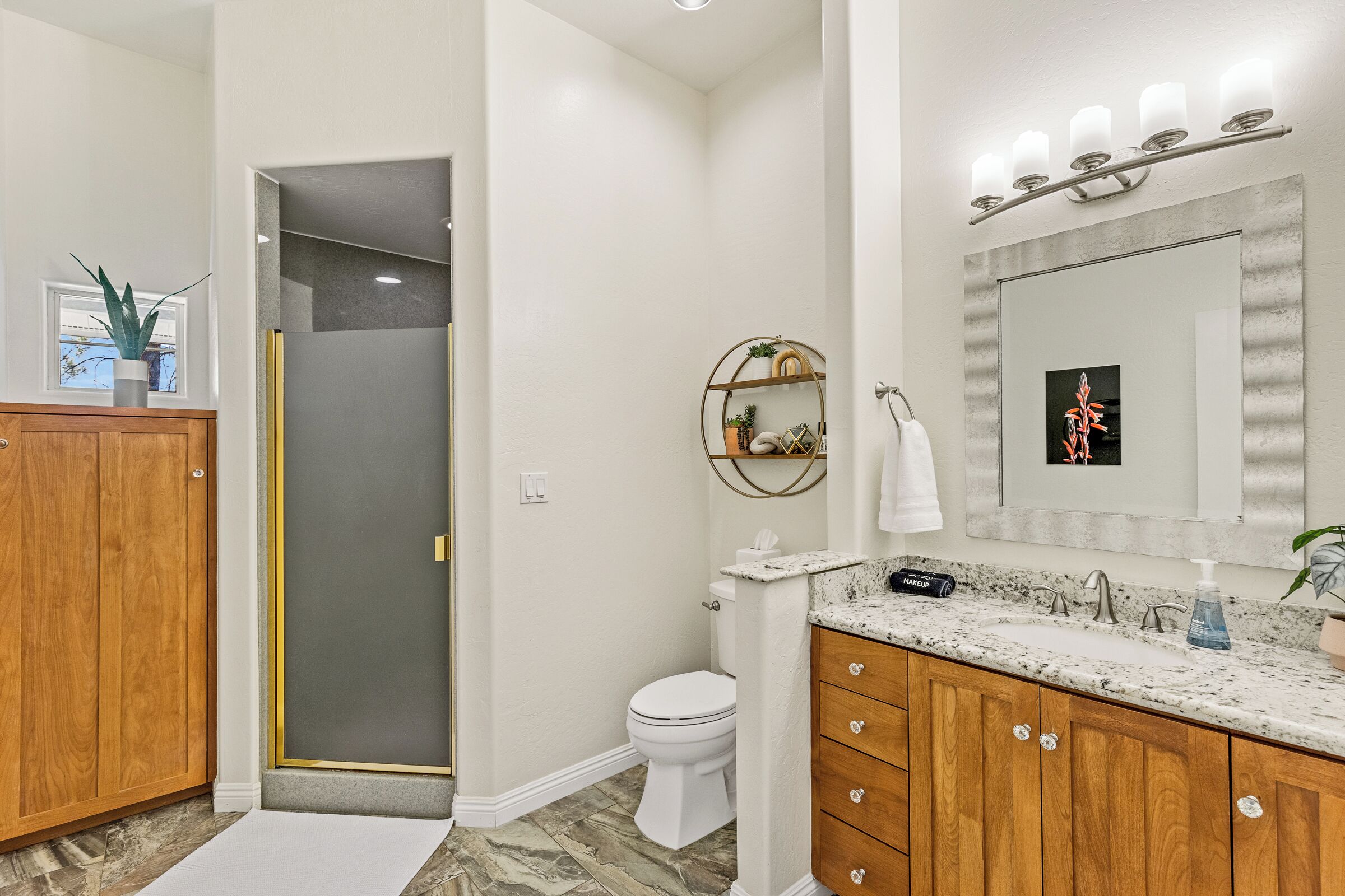 Ein Badezimmer mit Dusche, Toilette, Waschtisch und Spiegel.