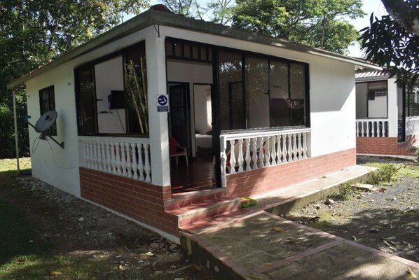 Situated in a wooded area, this charming building features a balcony and a small porch.