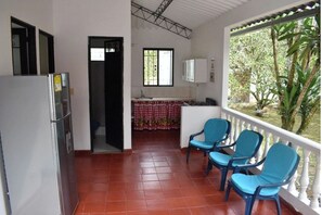 Enjoy a compact retreat with a kitchenette, dining area, and balcony overlooking a lush garden.
