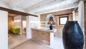 A kitchen with a stone wall, a green cabinet, a black vase, and a window. - Villa Casanostra 12, Emma Villas (San Ginesio)