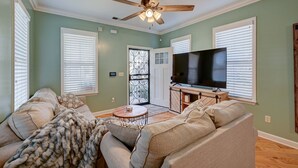 A living room with a ceiling fan, a TV, and two sofas.