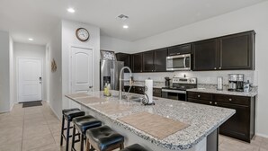 A modern kitchen with dark cabinets, stainless steel appliances, a granite countertop, and a built-in microwave. - East Valley Peaceful Oasis w/PRIVATE Pool that is HEATED at no extra cost (Florence)