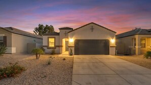 A residential house with a garage, a driveway, and a well-maintained garden. - East Valley Peaceful Oasis w/PRIVATE Pool that is HEATED at no extra cost (Florence)